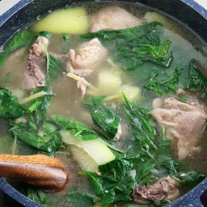 chicken tinola in a pot with spinach and green papaya