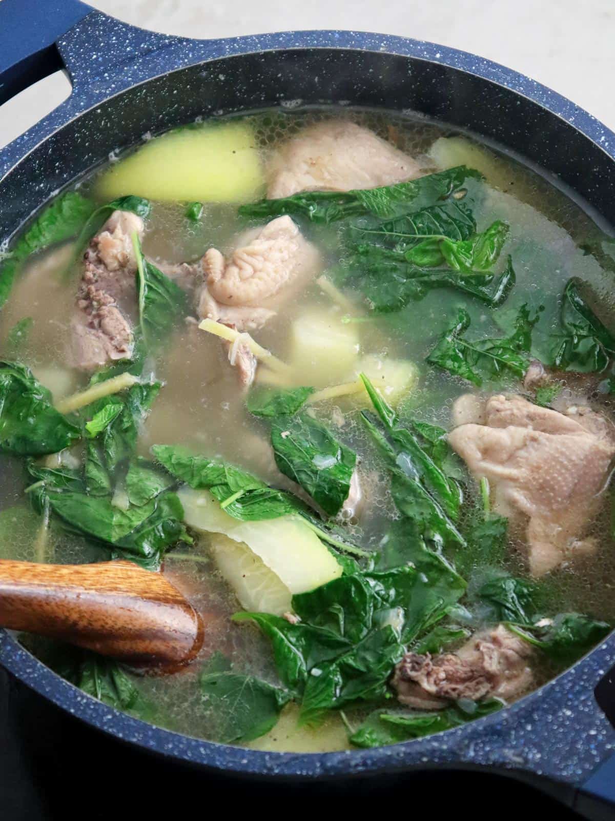 chicken tinola in a pot with spinach and green papaya