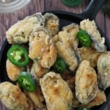crispy tahong with sliced jalapenos on a cast-iron skillet
