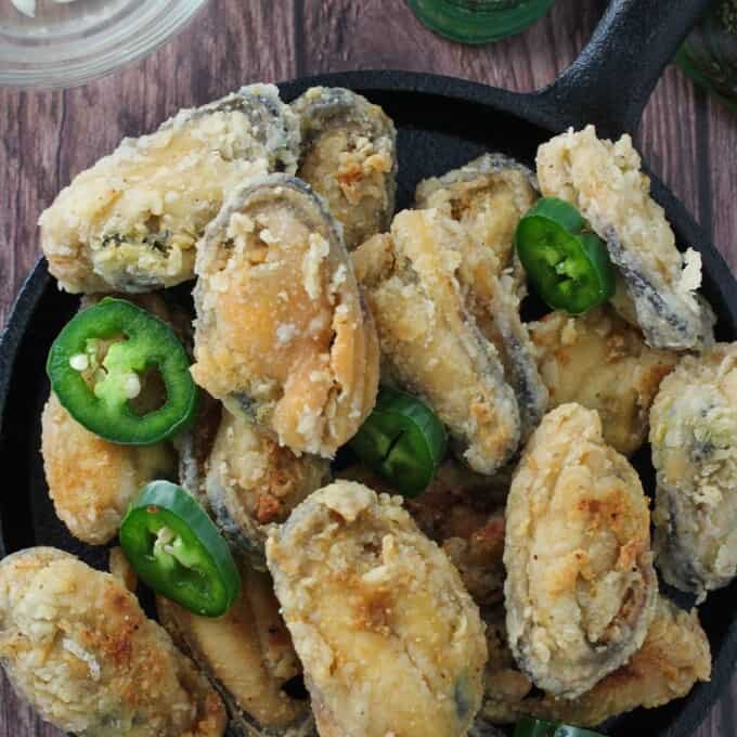 crispy tahong with sliced jalapenos on a cast-iron skillet