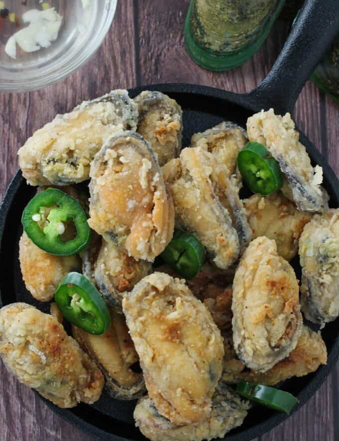 crispy tahong with sliced jalapenos on a cast-iron skillet