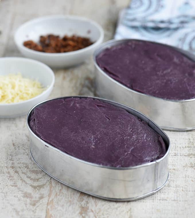 ube halaya in llaneras with bowls of shredded cheese and latk on the side