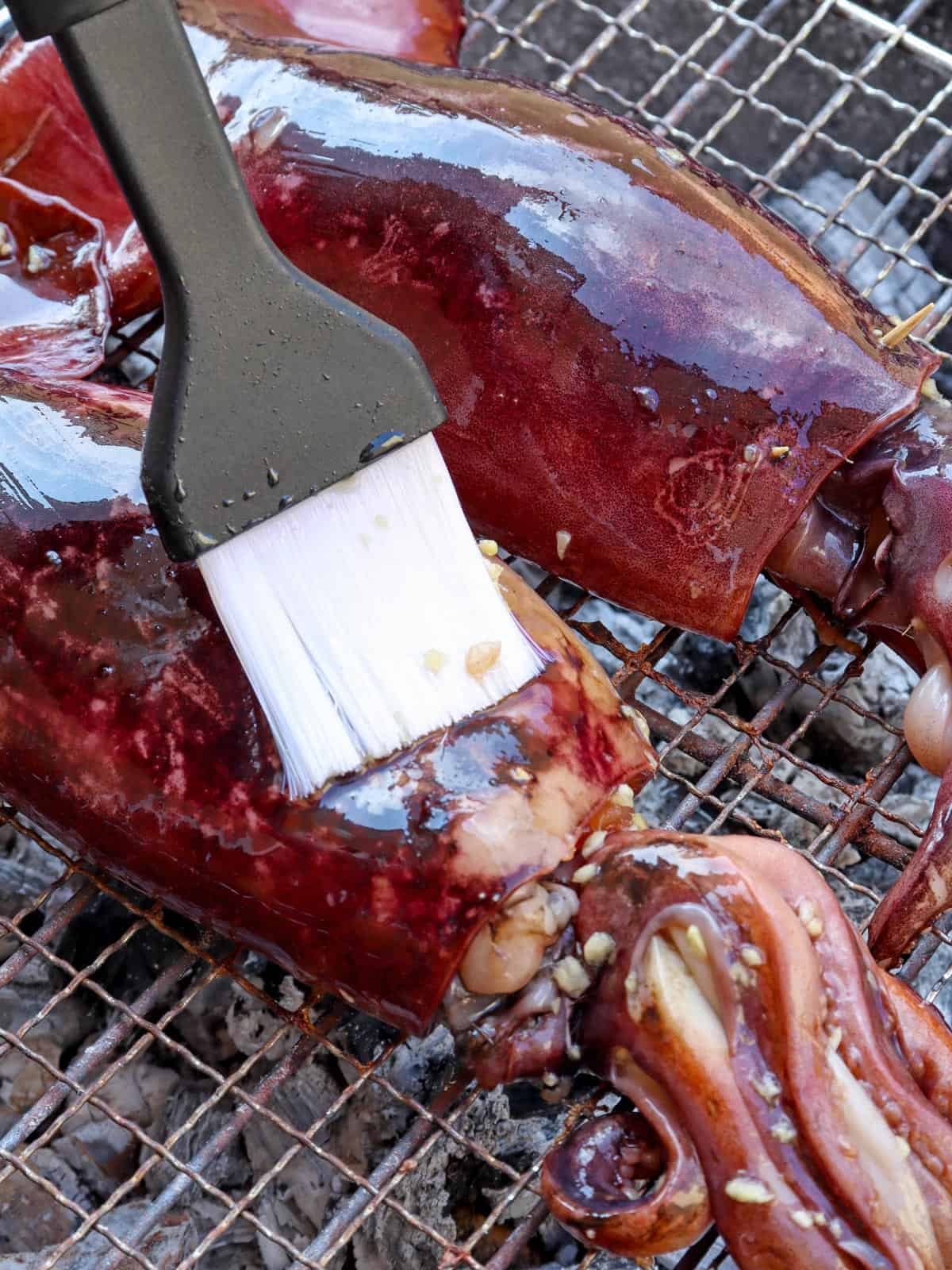 grilling stuffed jumbo squid on charcoal