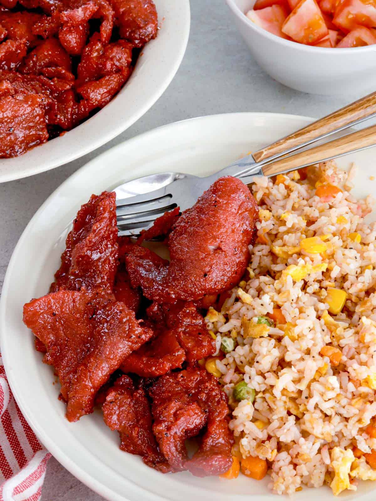 tocino with fried rice on a serving plate.