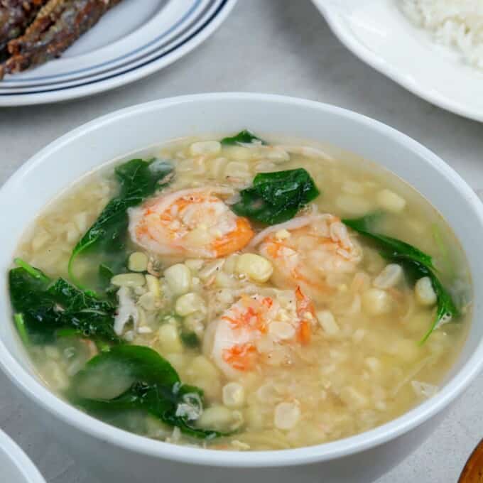 Suam na Mais in a white bowl with plate of rice on the side