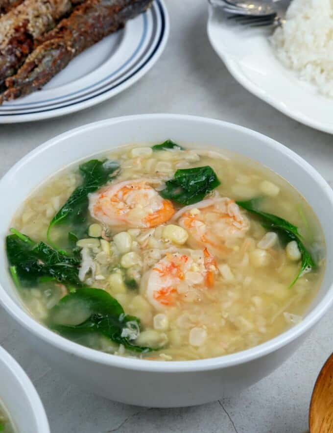 Suam na Mais in a white bowl with plate of rice on the side