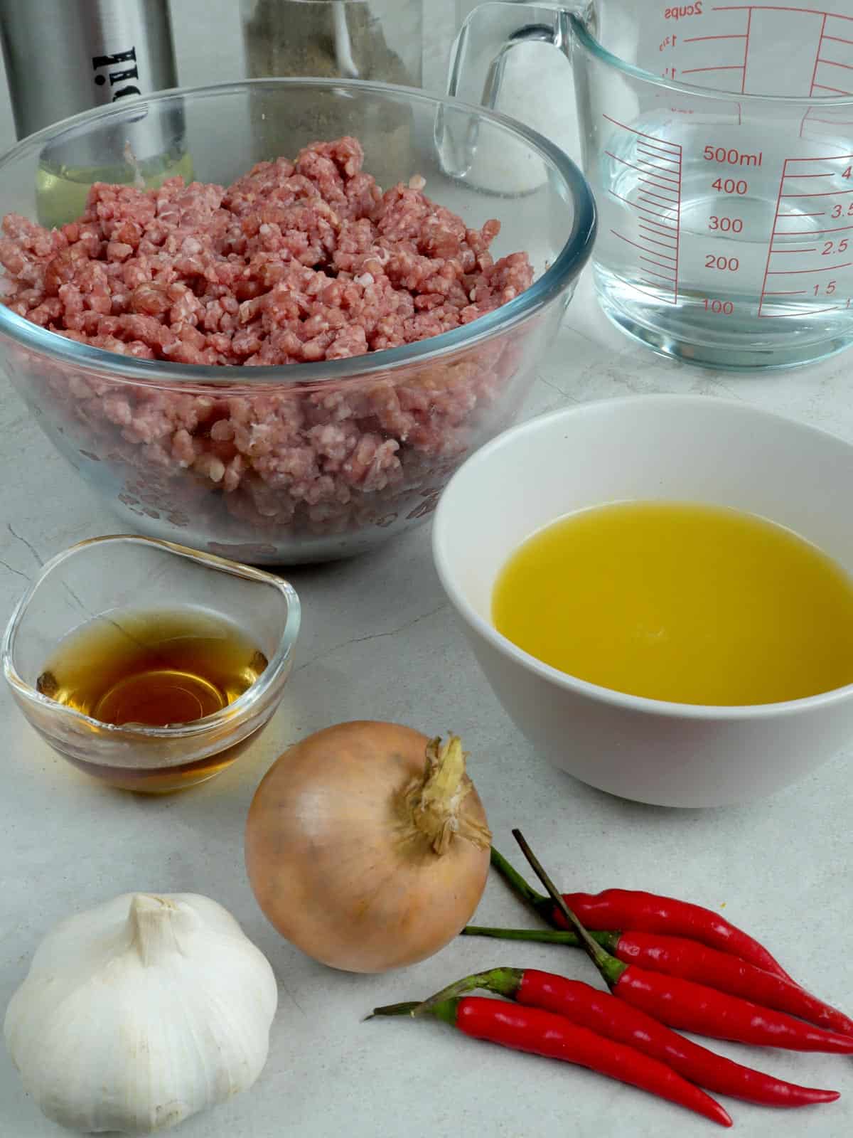 ground beef, calamansi juice, onion, garlic, chili peppers, fish sauce, water in bowls