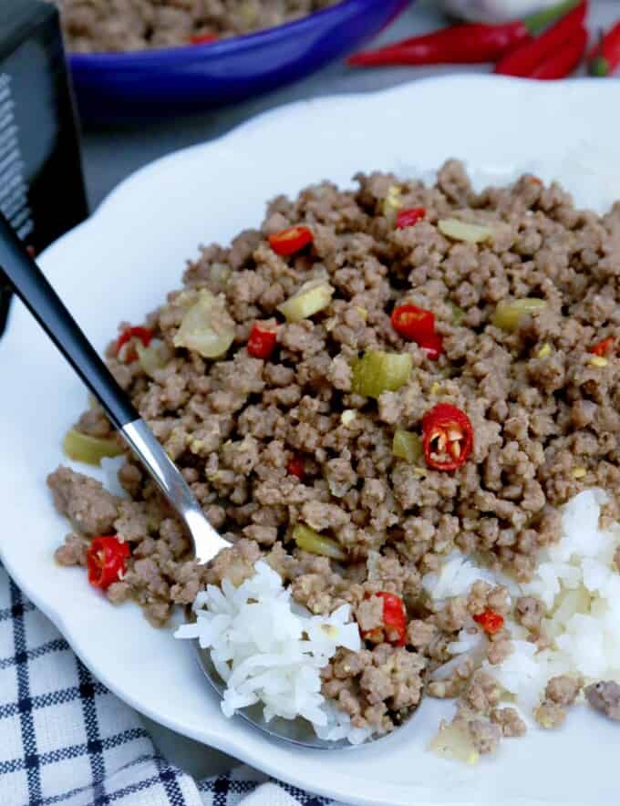 bagis with chopped red chili peppers over rice on a white serving plate