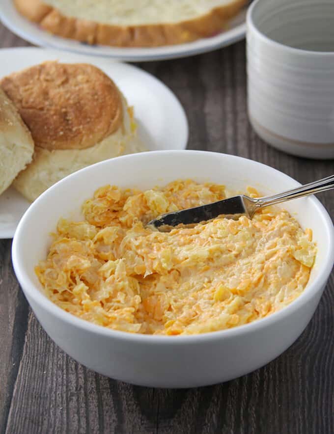 cheese pineapple spread in a white bowl with pandesal on the side