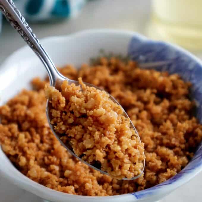 serving latik with a spoon from a bowl