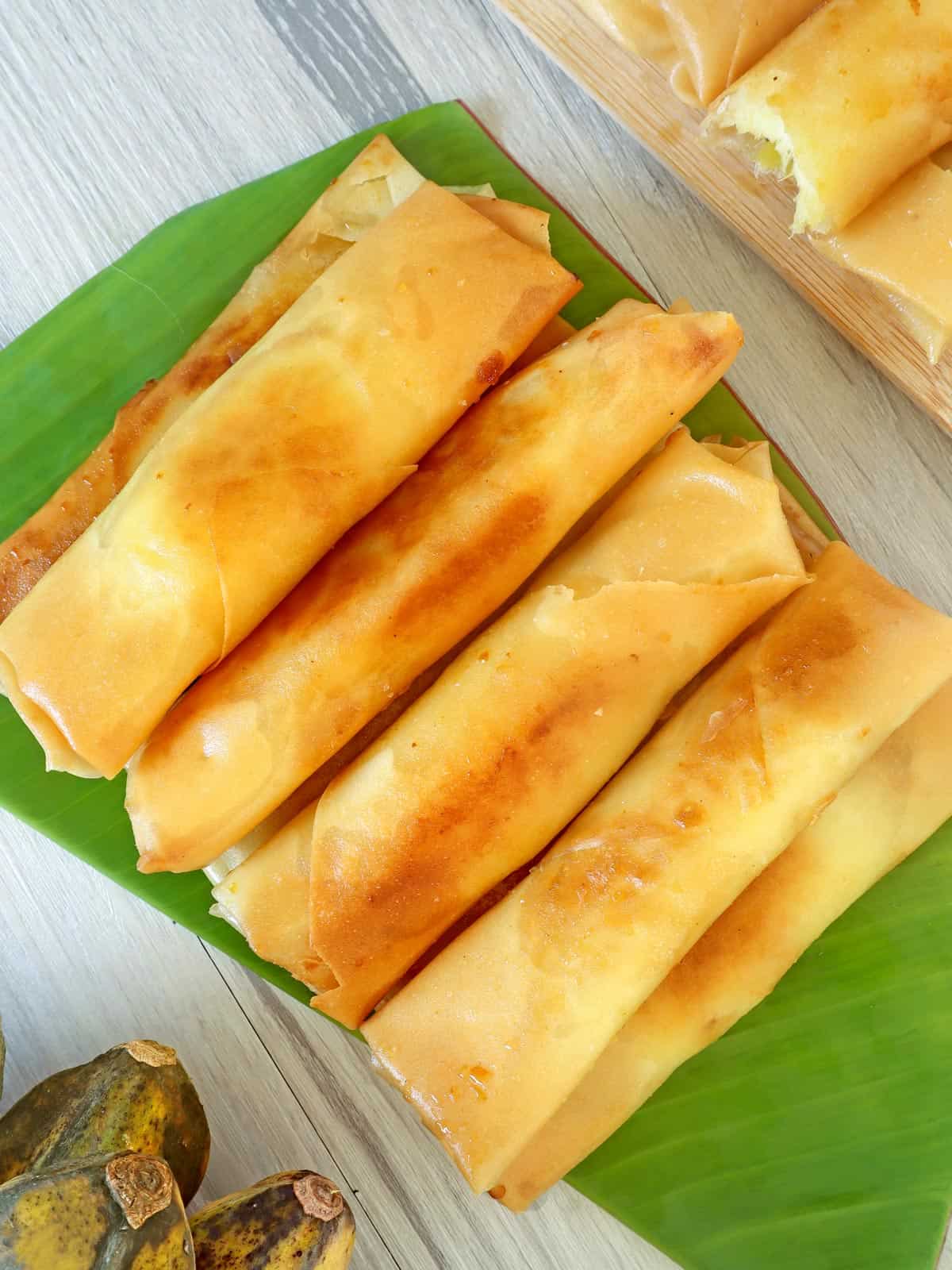 fried lumpiang saging on a banana-lined dish