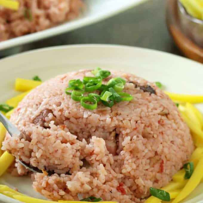 eating binagoongan rice with a fork on serving plate