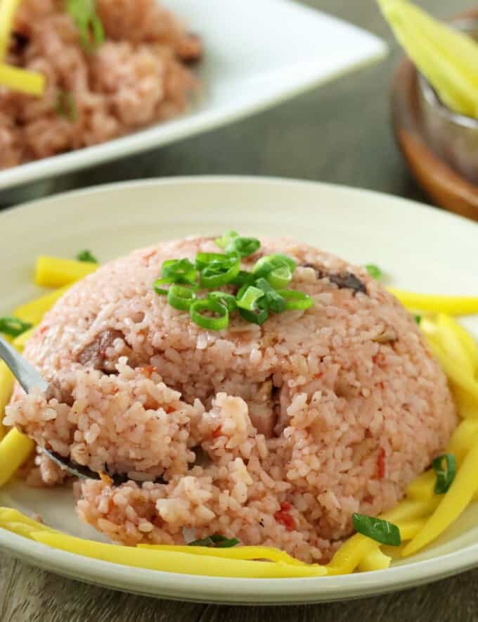 eating binagoongan rice with a fork on serving plate