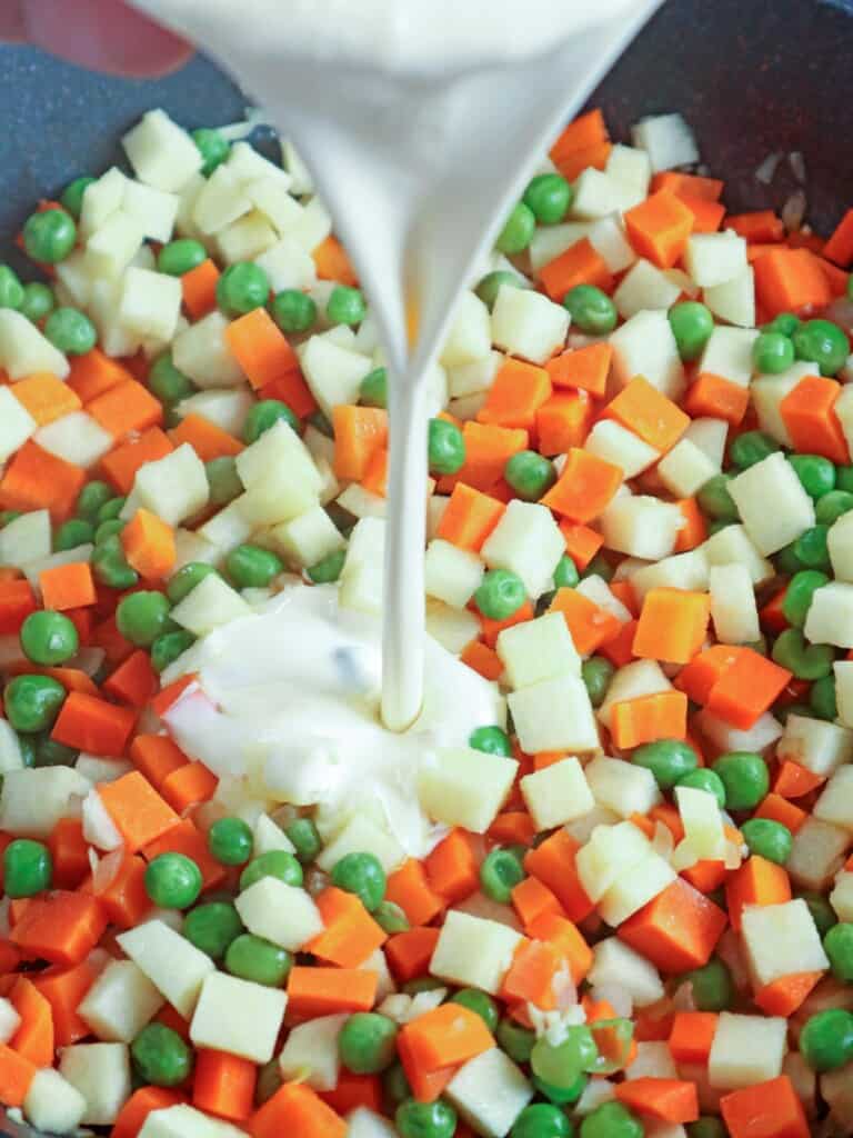 adding heavy cream to peas , carrots, and green peas