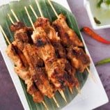 Filipino-style chicken bbq sticks on a white platter