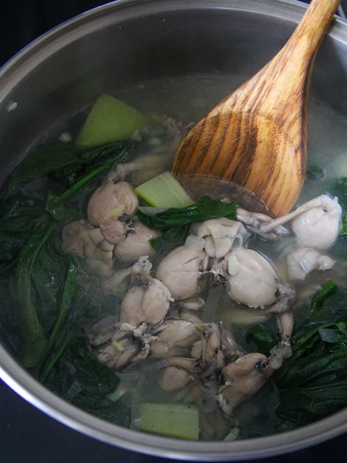 serving Tinolang Palaka from a pot with a wooden spoon.