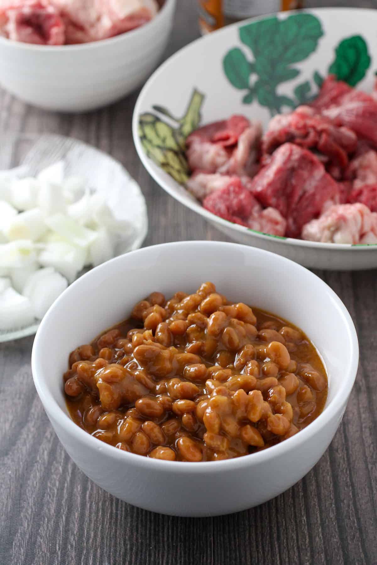 pork and beans, onions, beef, beef tendon in bowls