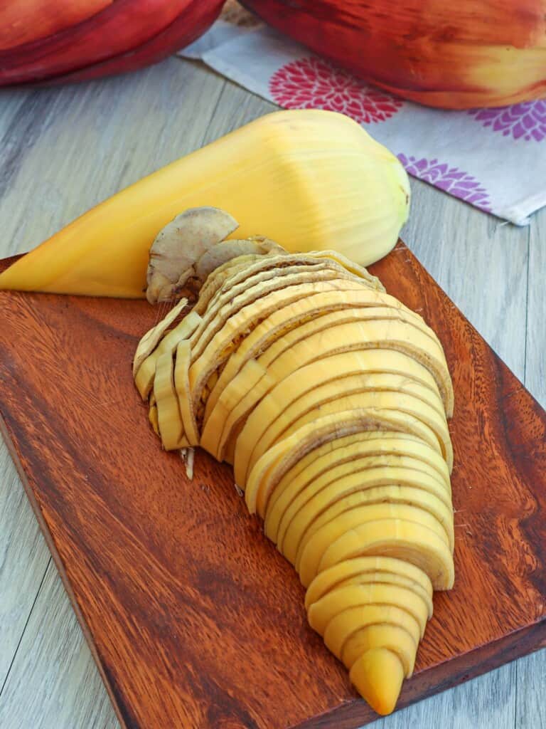 peeled and sliced banana heart on a cutting board