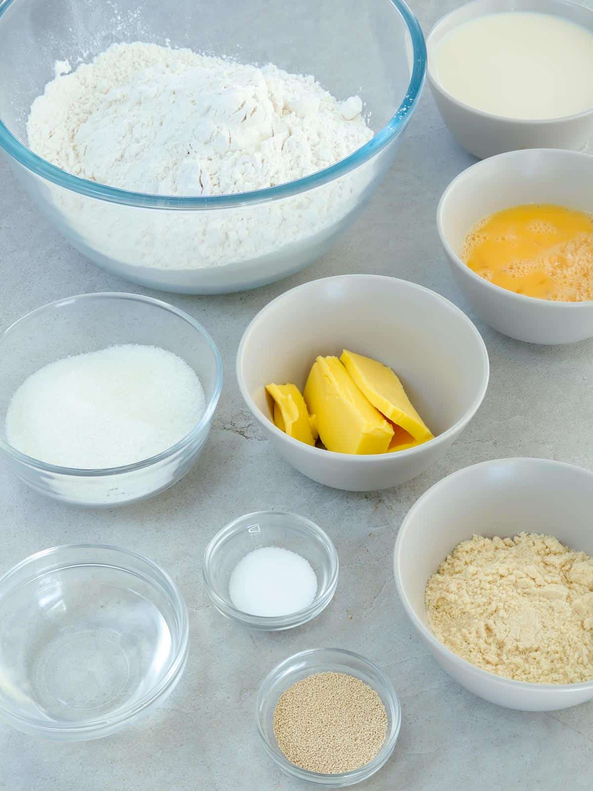 flour, butter, eggs, yeast, water, sugar, salt, milk in bowls