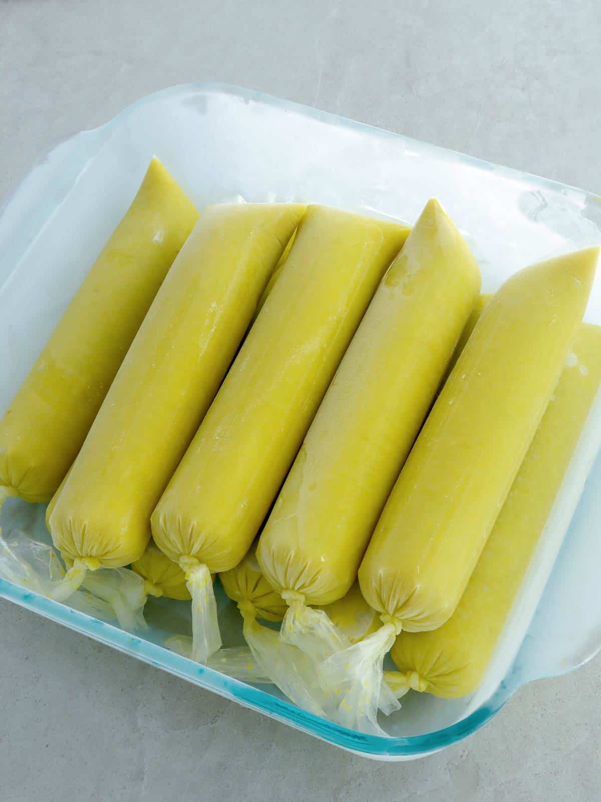 frozen avocado ice candies in a square glass pan.