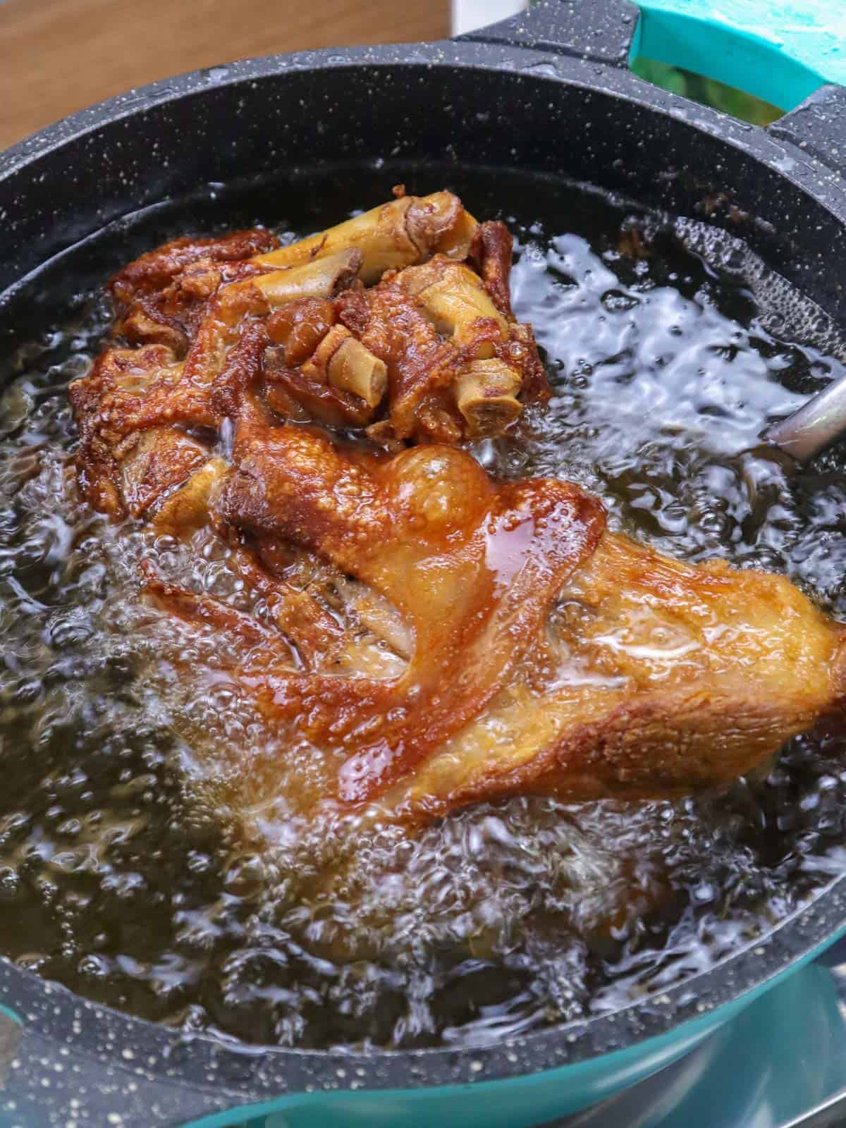 deep-frying whole pork let in a pot.