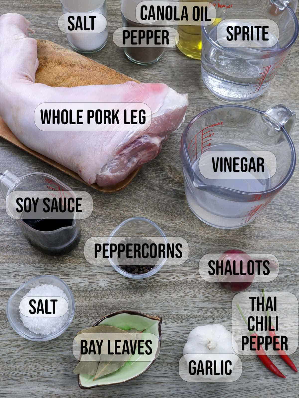 pork leg, vinegar, water, garlic, onions, peppercorns, soy sauce, chili peppers, salt, shallots in bowls.