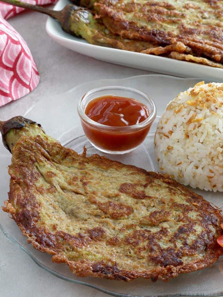 eggplant omelette on a plate with steamed rice and ketchup