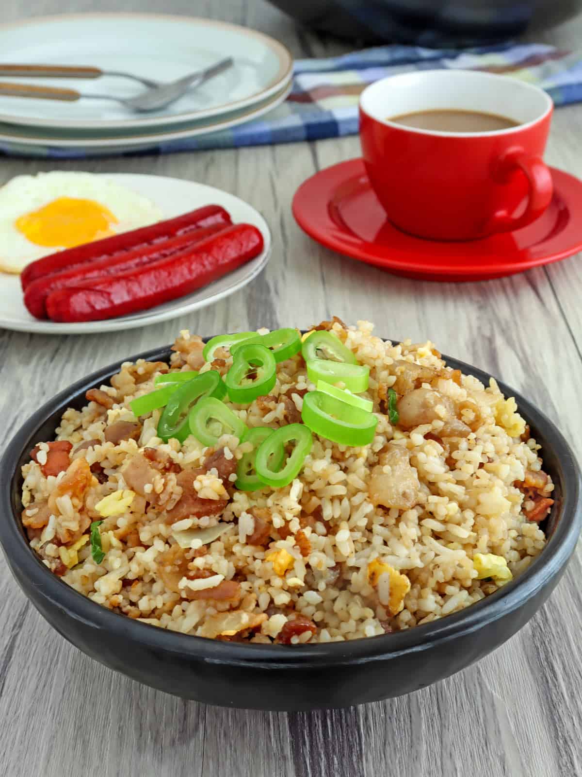 Bacon Fried Rice in a bowl with a side of fried egg and hotdogs