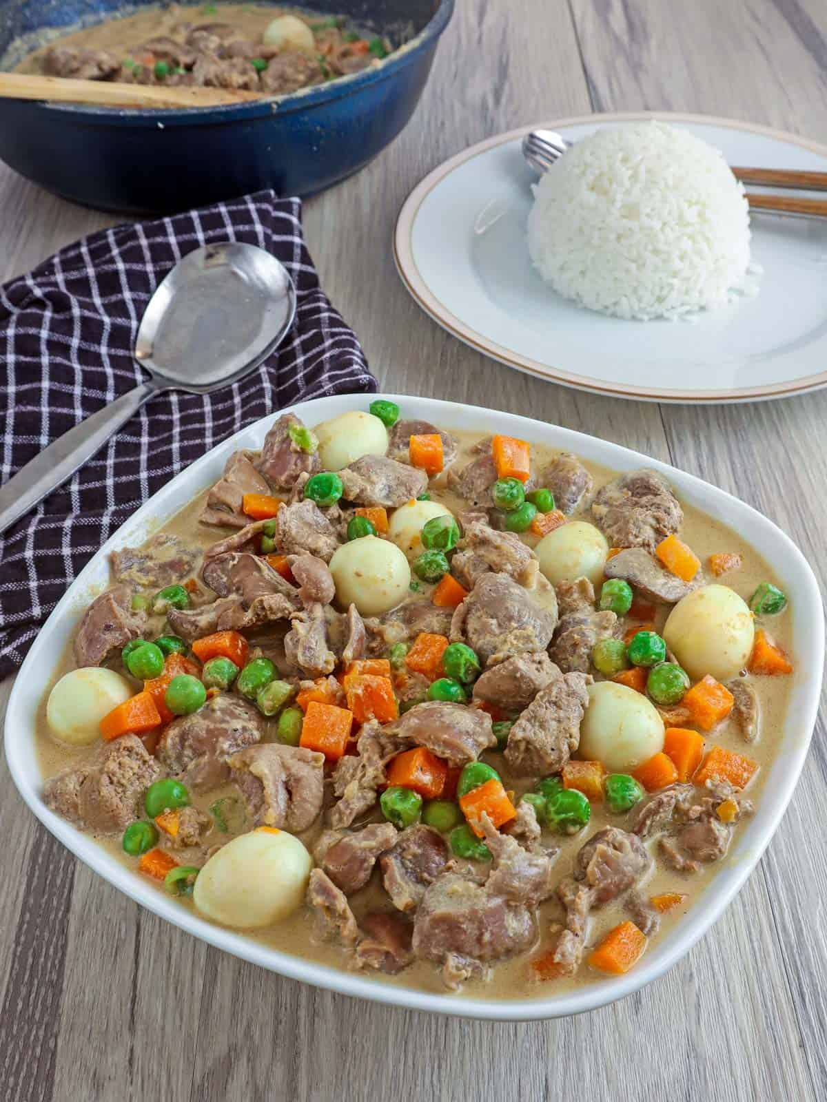 Liver and Gizzard with Sweet Peas in a serving bowl with a side of steamed rice