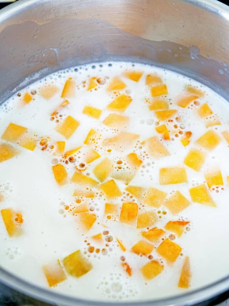 cooking calabasa in sweetened coconut milk in a pot