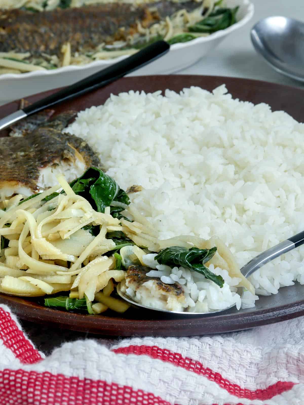 inabraw na saluyot at labong on a serving plate with steamed rice.