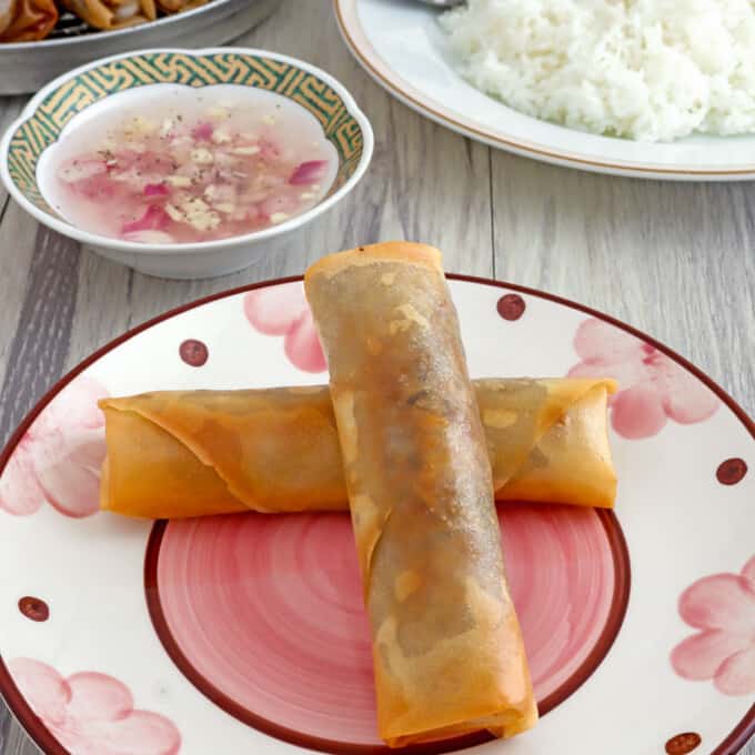 Lumpiang Puso ng Saging on a plate with spicy vinegar and steamed rice on the side