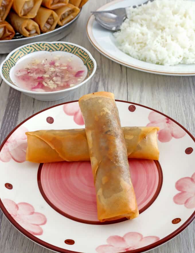 Lumpiang Puso ng Saging on a plate with spicy vinegar and steamed rice on the side