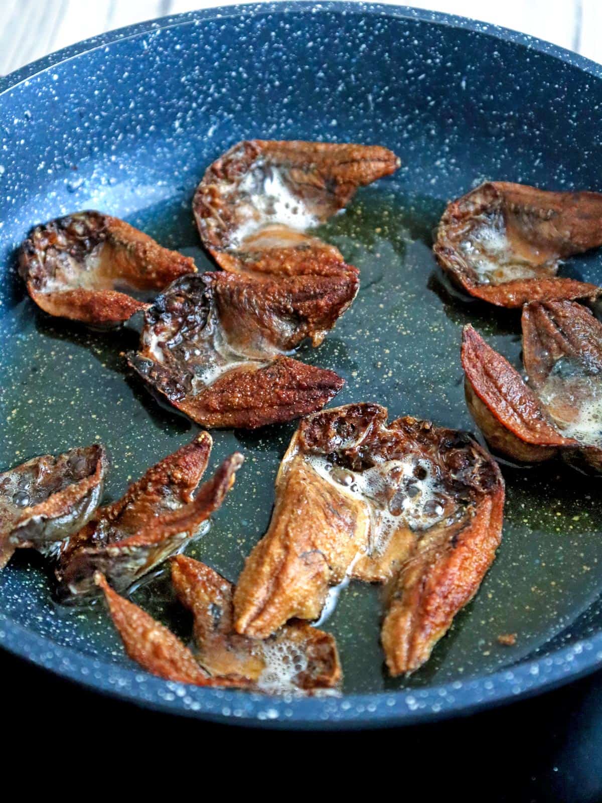 frying dried fish in a pan