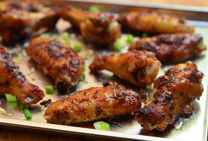 These oven baked honey chicken wings are served with fresh green onions. 
