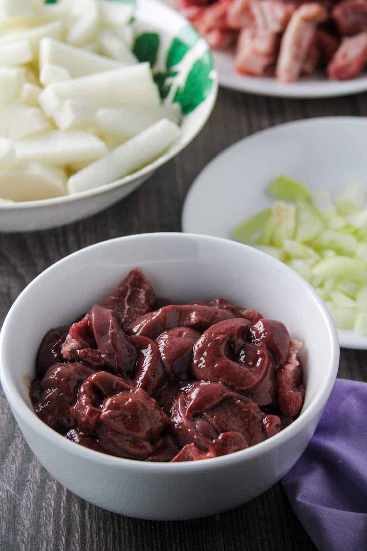 sliced liver, radish, pork, onion in individual bowls