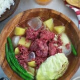 corned beef nilaga in a wooden bowl with a plate of rice on the side