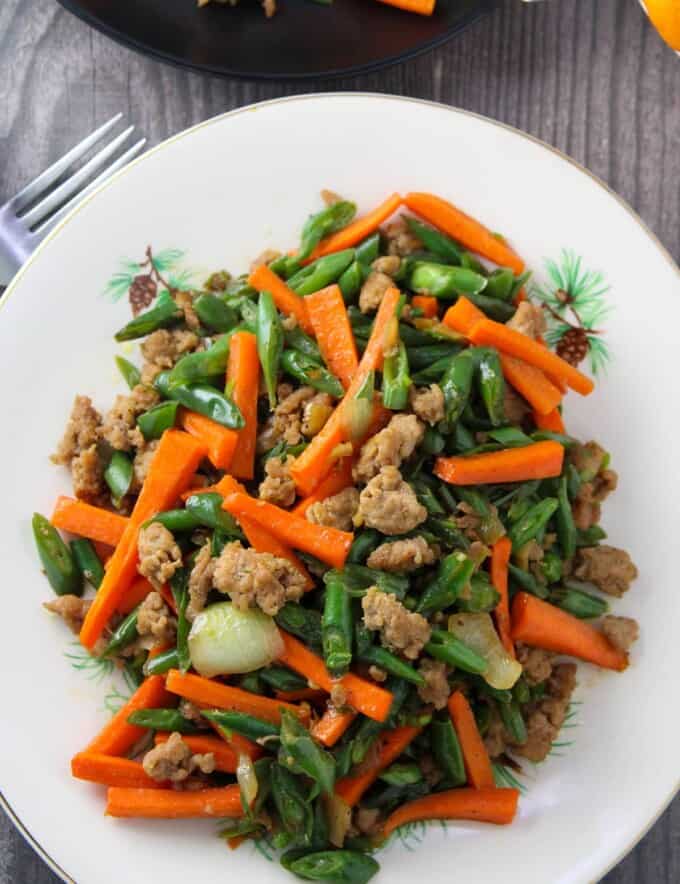 green bean stir-fry with carrots and minced pork on a white serving platter