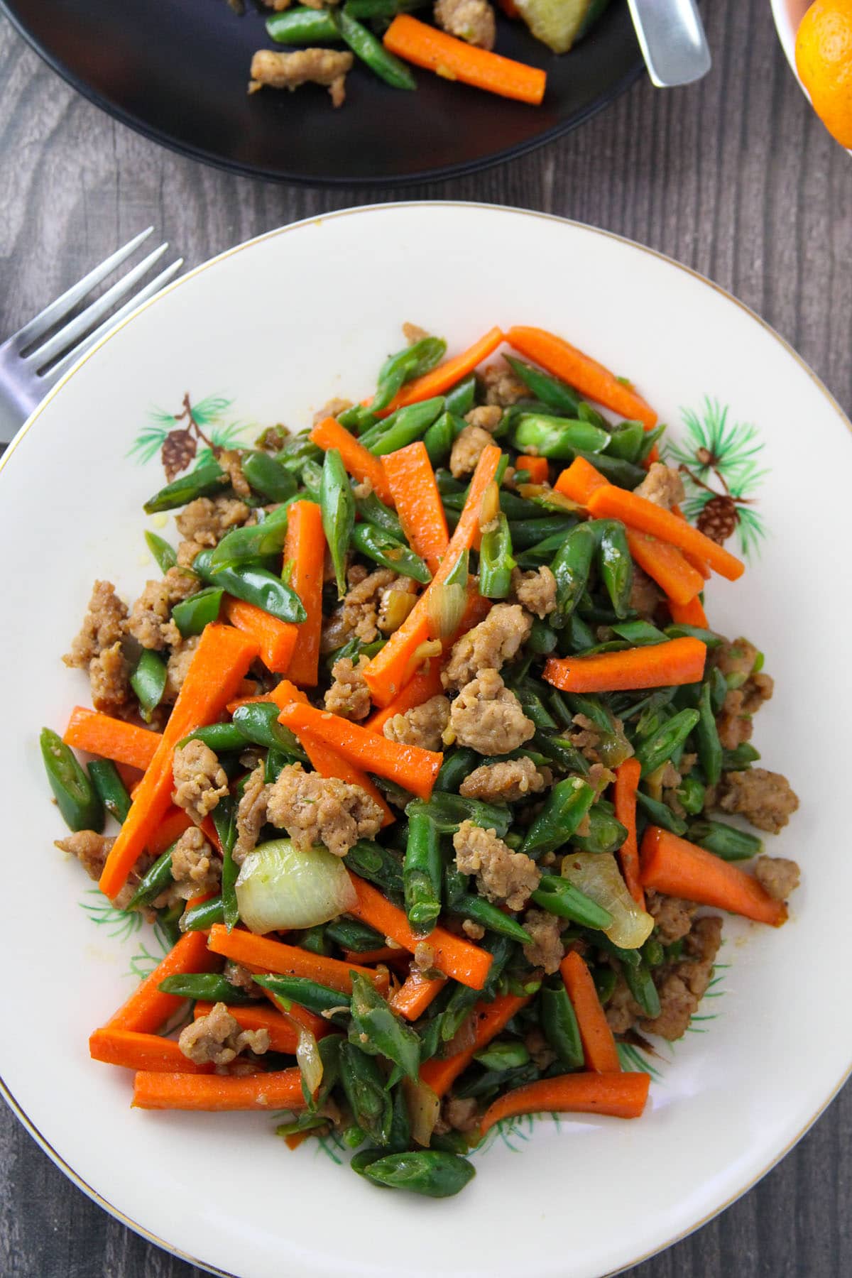 green bean stir-fry with carrots and minced pork on a white serving platter