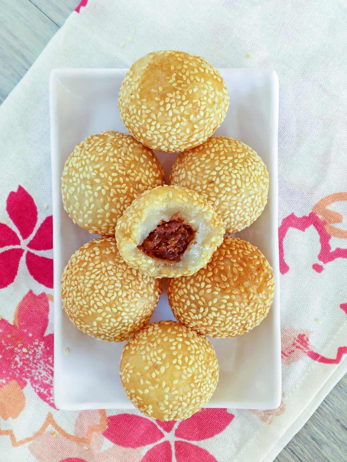 sesame balls with red bean filling on a white plate