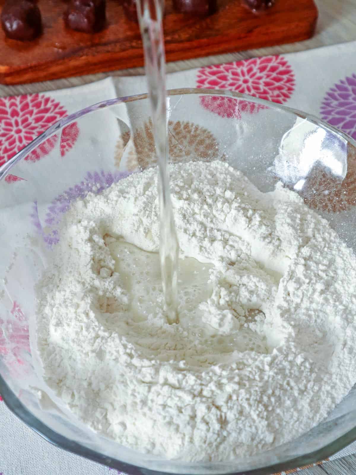 pouring hot water on glutinous rice flour in a glass bowl