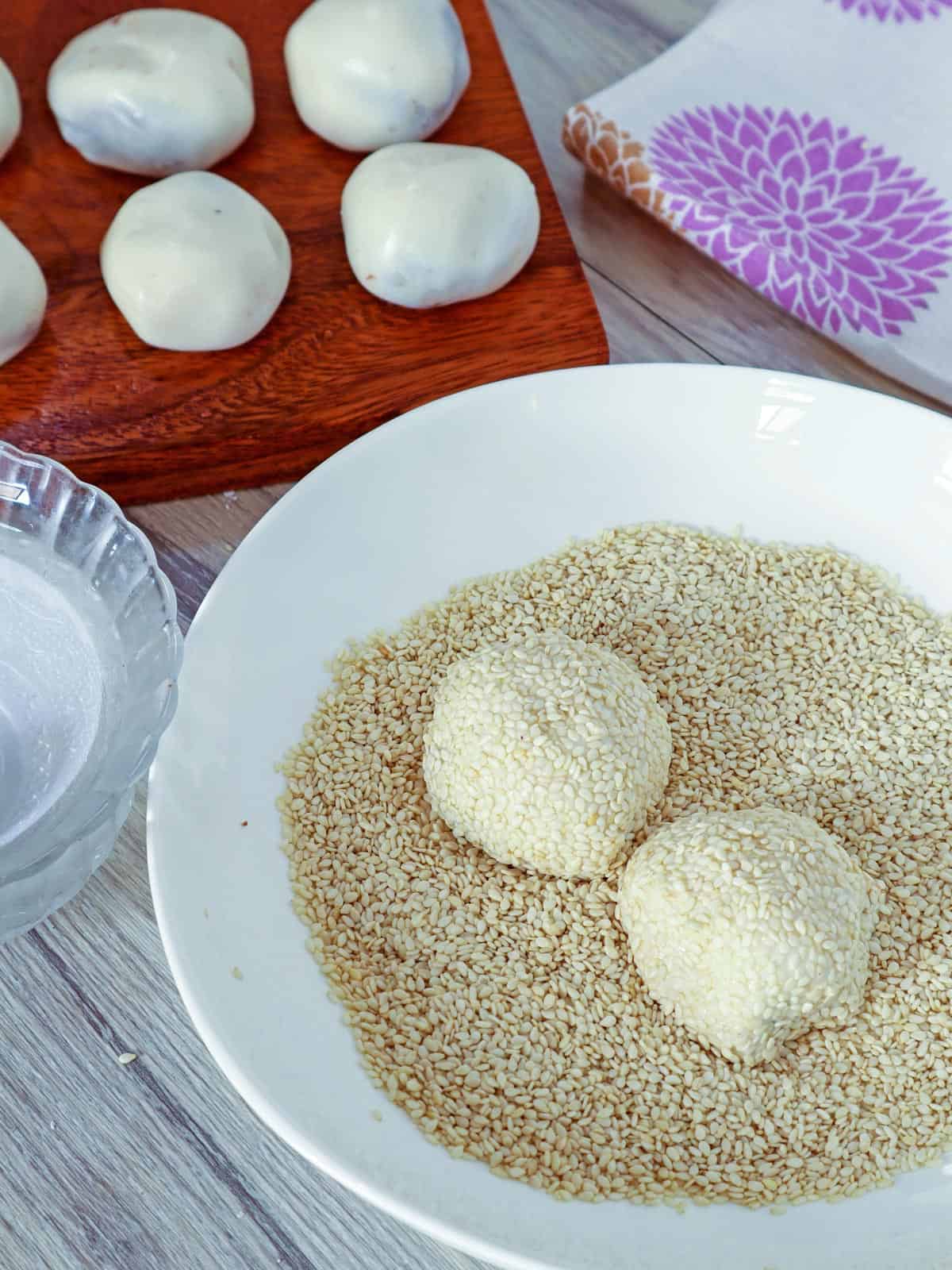 rolling buchi in sesame seeds