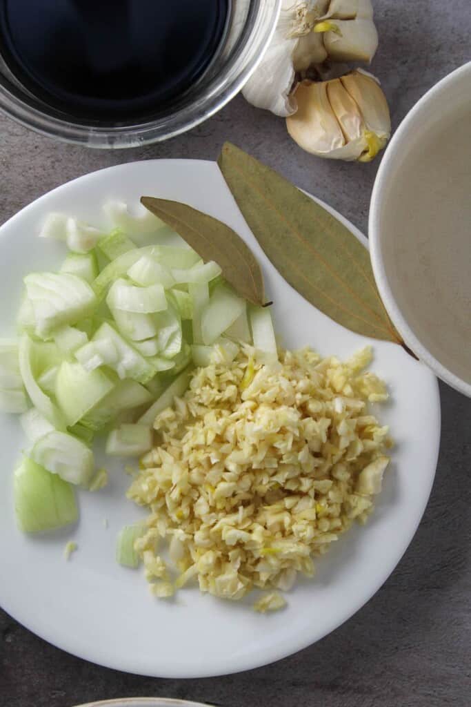 chopped onions, minced garlic, bay leaves, vinegar, soy sauce