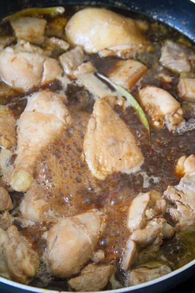 simmering pork and chicken in adobo seasonings
