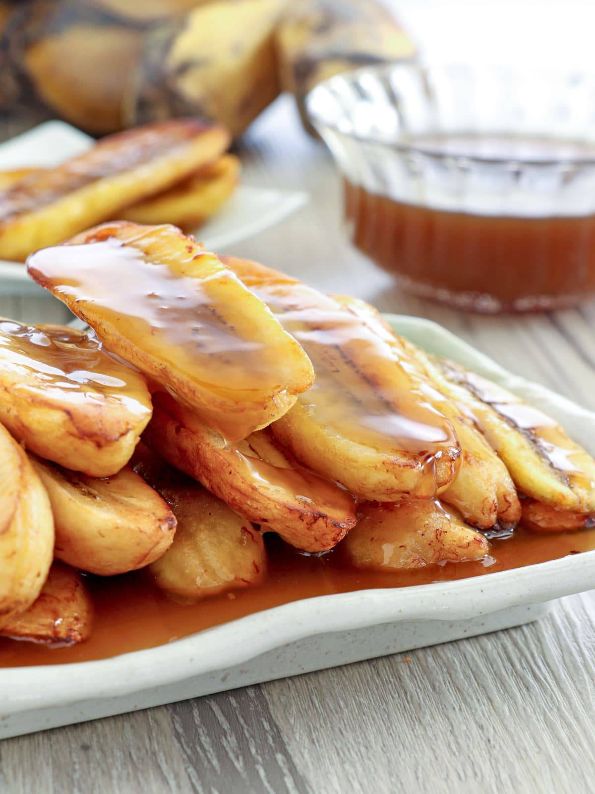 fried saba bananas with latik sauce in a white serving platter