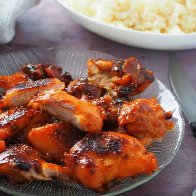 cut up Chicken Tocino on a clear glass serving platter