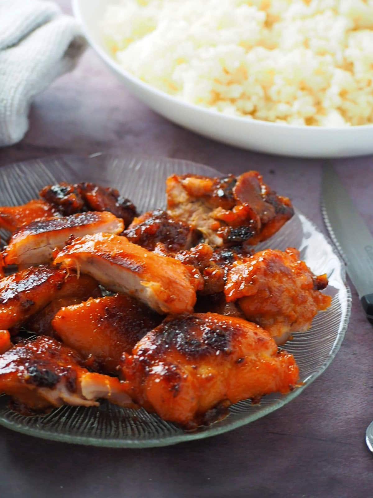 cut up Chicken Tocino on a clear glass serving platter