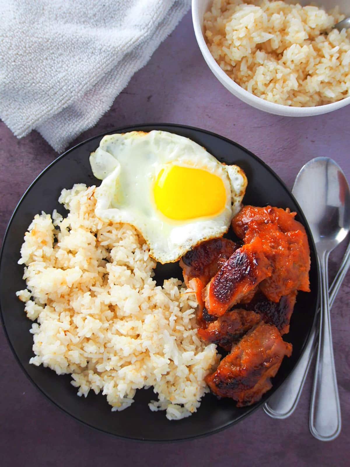 chicken tocilog on a black plate