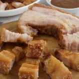 crispy pork belly on a wooden chopping board