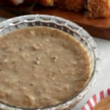 Lechon Sauce in a clear bowl with lechon kawali on the side